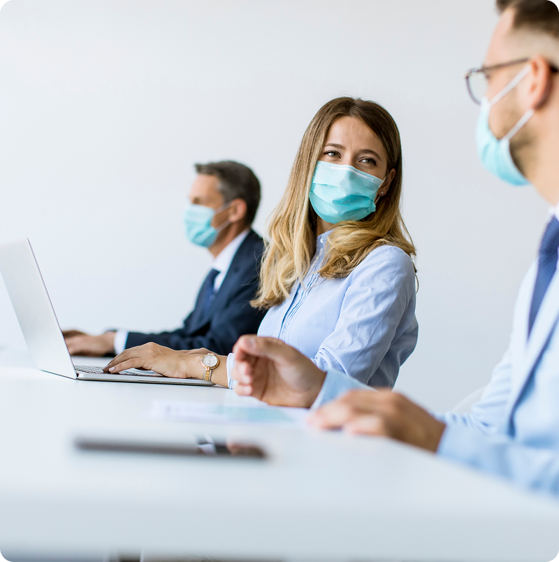 Personal administrativo de salud con mascarillas trabajando en oficina y consultando información.
